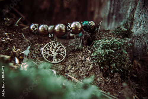 amulet lying on a moss on a dark natural background. pagan wiccan, slavic traditions. Witchcraft, esoteric spiritual ritual for mabon, samain photo