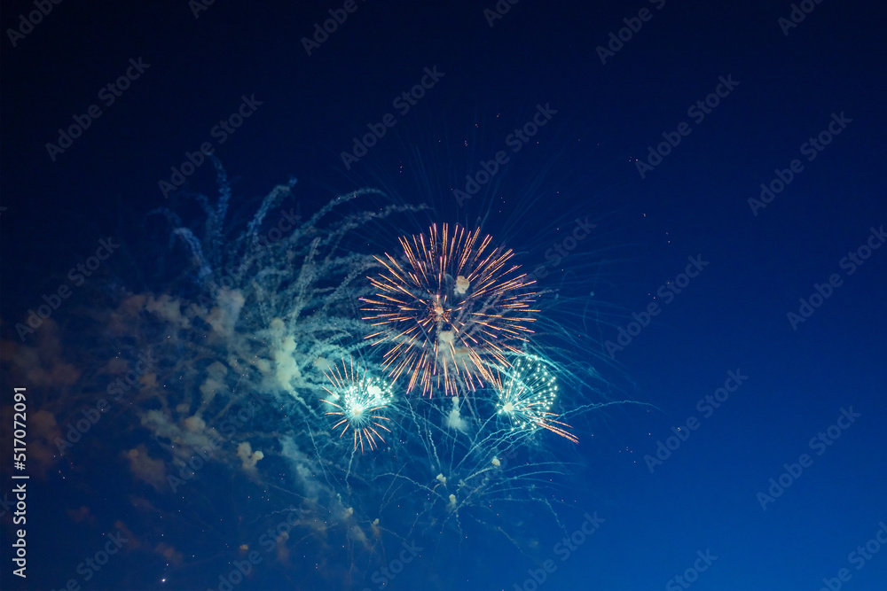 Obraz premium Firework over the blue sky at night, white, and green. Amateur photo. Noise. Grain.