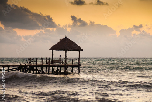 PIer with tiki hut in the ocean at sunrise Solidaridad  Quintana Roo  Riviera Maya  Mexico