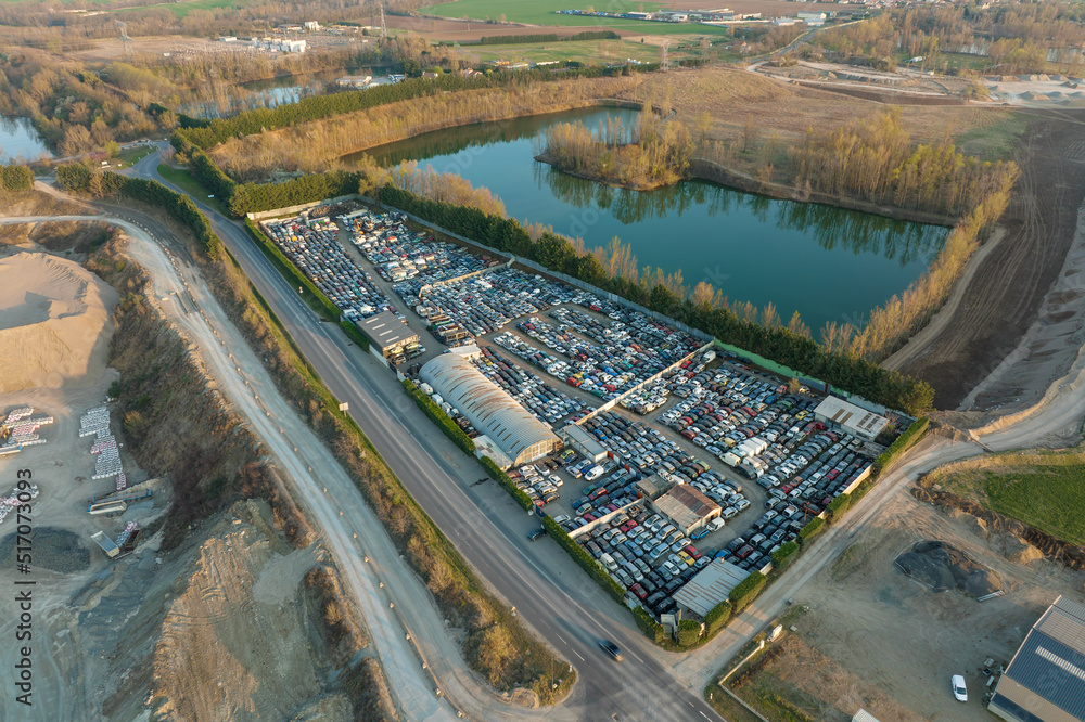 Aerial view of big parking lot of junkyard with rows of discarded broken cars. Recycling of old vehicles