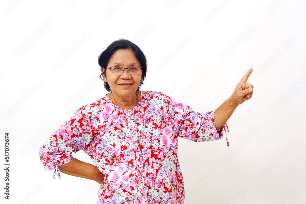 Happy asian elderly woman standing while pointing sideways. Isolated on white background Happy asian elderly woman standing while pointing sideways. Isolated on white background
