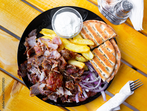 Meat souvlaki served with French fries, onions and pita bread. Albanian cuisine photo
