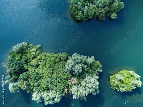 Aerial down view of 3 islands on a tranquil clear water lake in Hertfordshire UK