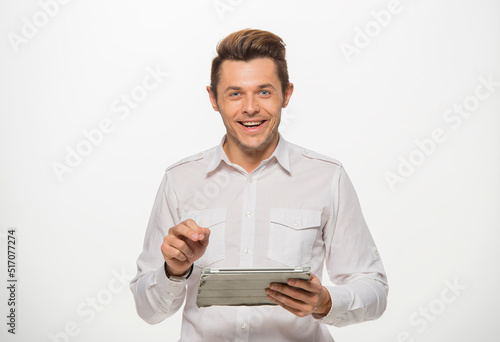 a man in a white shirt uses a tablet on a white isolated background.close-up portrait of a man with a tablet emotionally