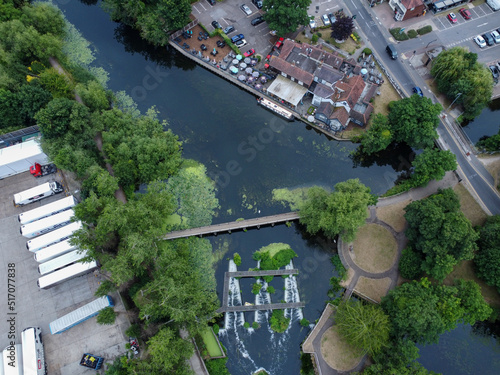 Aerial view of weir and pub on a river in Hoddesdon, with clear tranquil water
