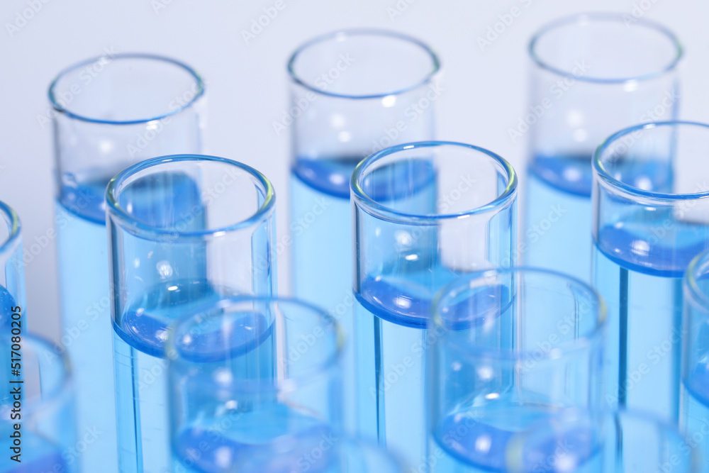 Test tubes with reagents on light blue background, closeup. Laboratory analysis Test tubes with reagents on light blue background, closeup. Laboratory analysis