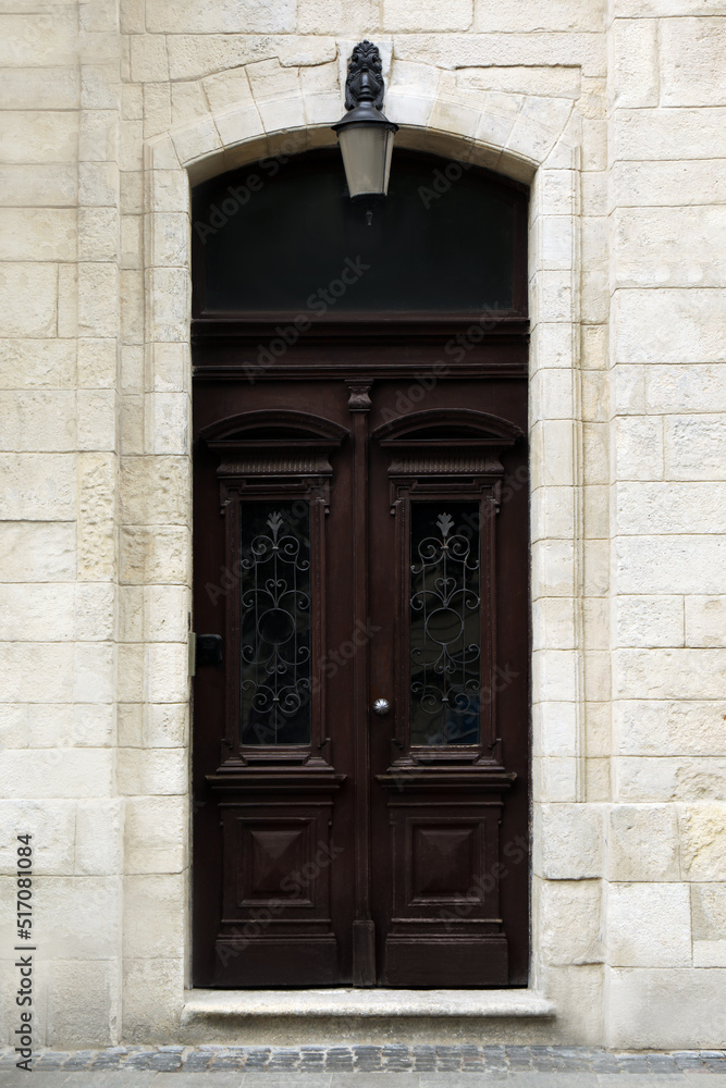 View of house with beautiful arched wooden door. Exterior design