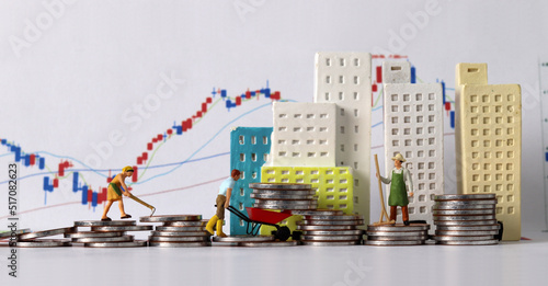 The concept of real estate investment. Business concept with miniature people and coins and graph. 