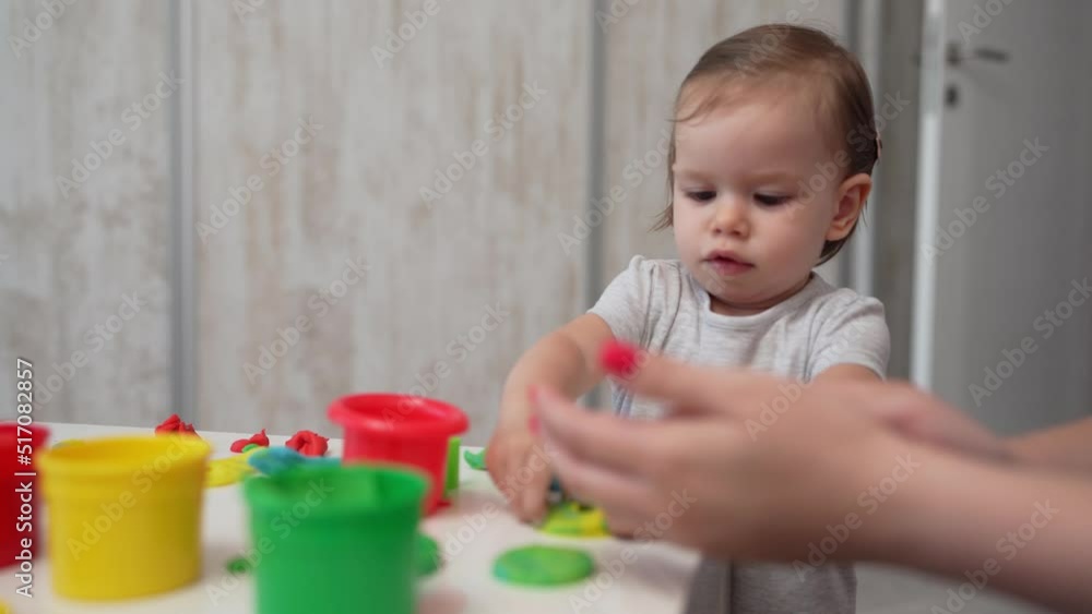 One girl small caucasian toddler child playing with colorful plasticine on the table at home childhood and growing up development concept
One girl small caucasian toddler child playing with colorful plasticine on the table at home childhood and growing up development concept