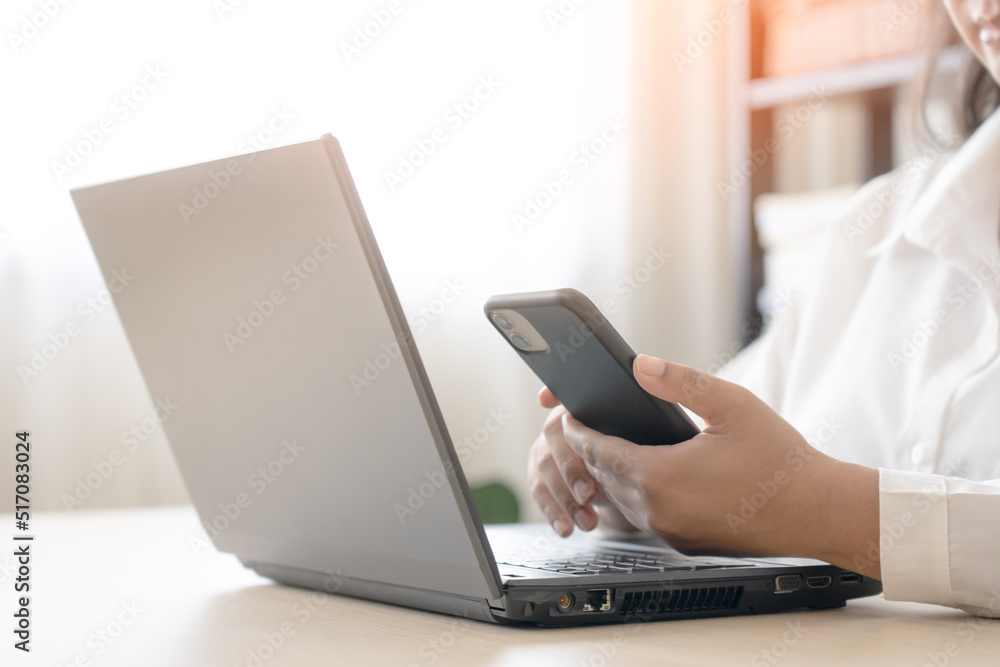 Woman using mobile phone and laptop for tele communication work. Connecting to office using wireless technology. Woman using mobile phone and laptop for tele communication work. Connecting to office using wireless technology.