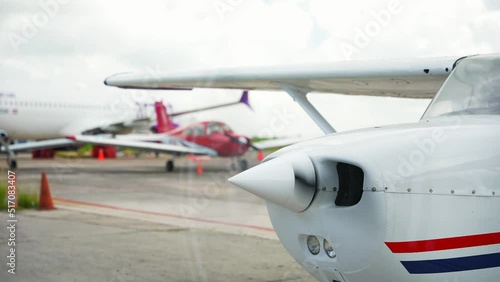 Close-up of rotationg proppeler of a small single engine airplane on runway in airport photo