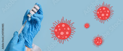 Hands of doctor with monkeypox vaccine and syringe on blue background. Banner for design photo