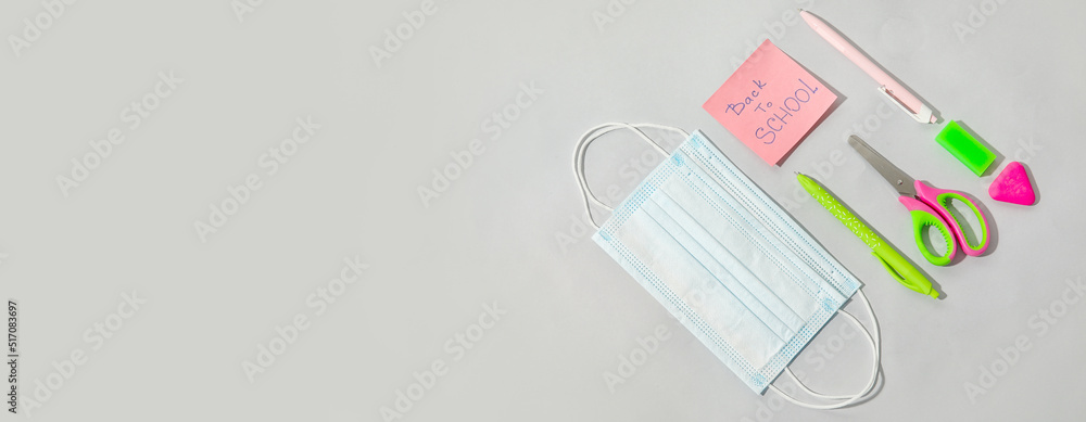 Set of school stationery and medical mask on light background with space for text Set of school stationery and medical mask on light background with space for text