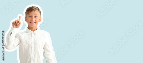 Little schoolboy with raise...