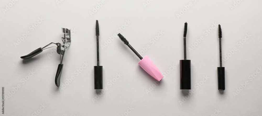 Black mascara and eyelash curler on light background Black mascara and eyelash curler on light background