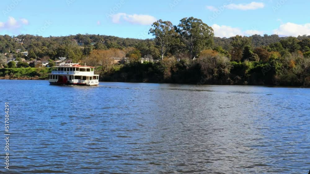 The Nepean Belle Paddle-wheeler moving slowly along the Nepean River on a sunny blue sky day The Nepean Belle Paddle-wheeler moving slowly along the Nepean River on a sunny blue sky day
