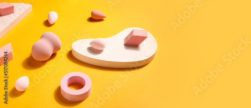 Makeup sponges and decor on yellow background with space for text