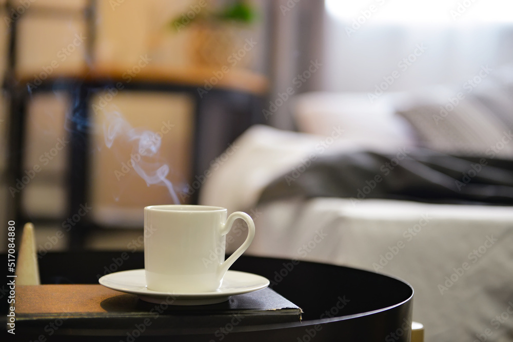 Cup of hot coffee with book on table in bedroom, closeup Cup of hot coffee with book on table in bedroom, closeup