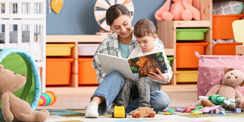 Nanny and little boy reading interesting book in room