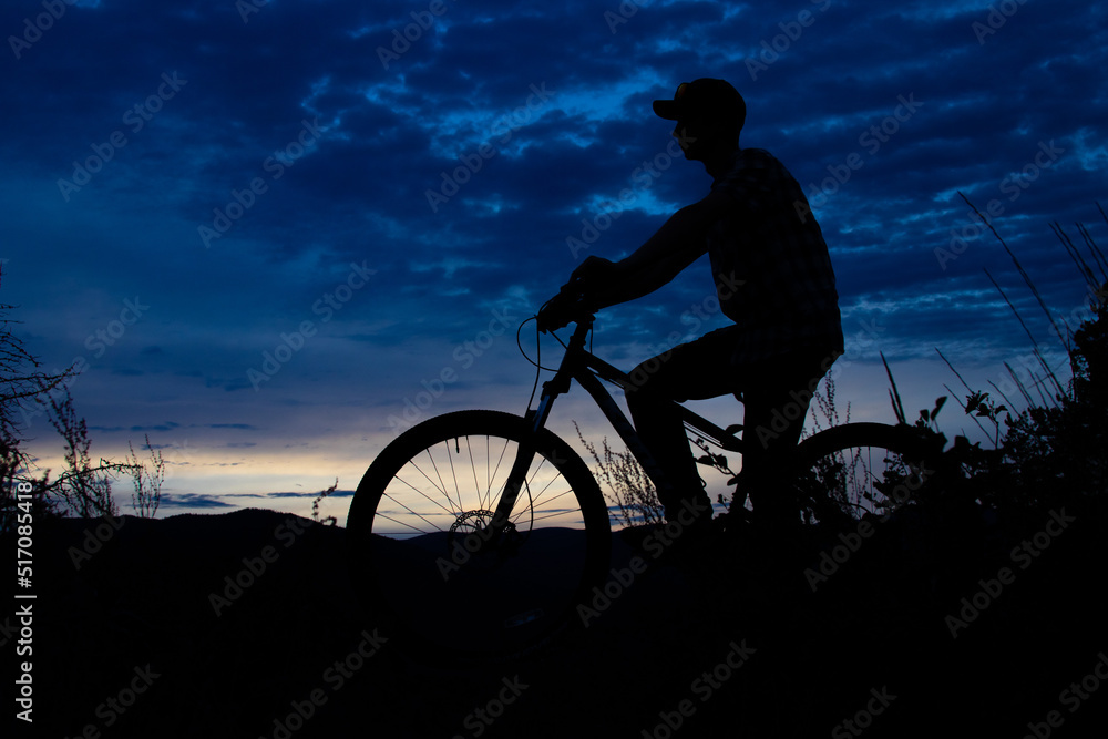 Obraz premium Silhouette of boy on mountain bike