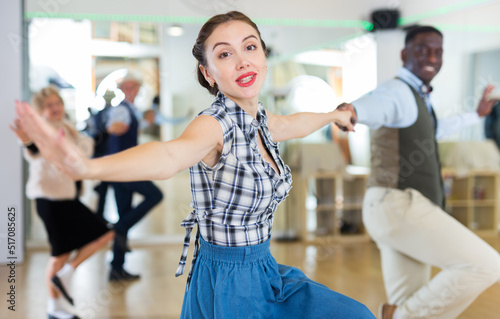Cheerful female practicing lindy hop in pair with man