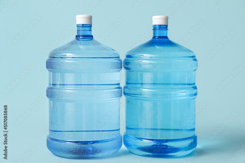Bottles of clean water on light blue background