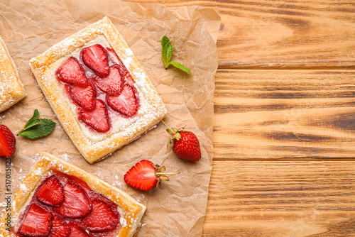 Delicious strawberry puff pastry on wooden background