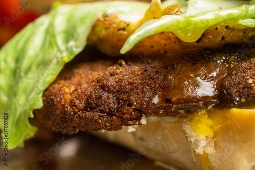 fried egg beef or chicken milanese in breadcrumbs with lettuce and tomato on a dark background