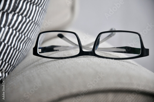 A glasses on the corner of sofa