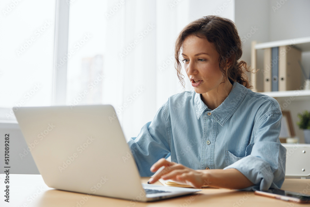 Angry evil pretty curly businesswoman worker screaming to desktop Raging after computer software crash error sitting at workplace in home modern office. Technology Gadget Crash Concept. Copy space Angry evil pretty curly businesswoman worker screaming to desktop Raging after computer software crash error sitting at workplace in home modern office. Technology Gadget Crash Concept. Copy space