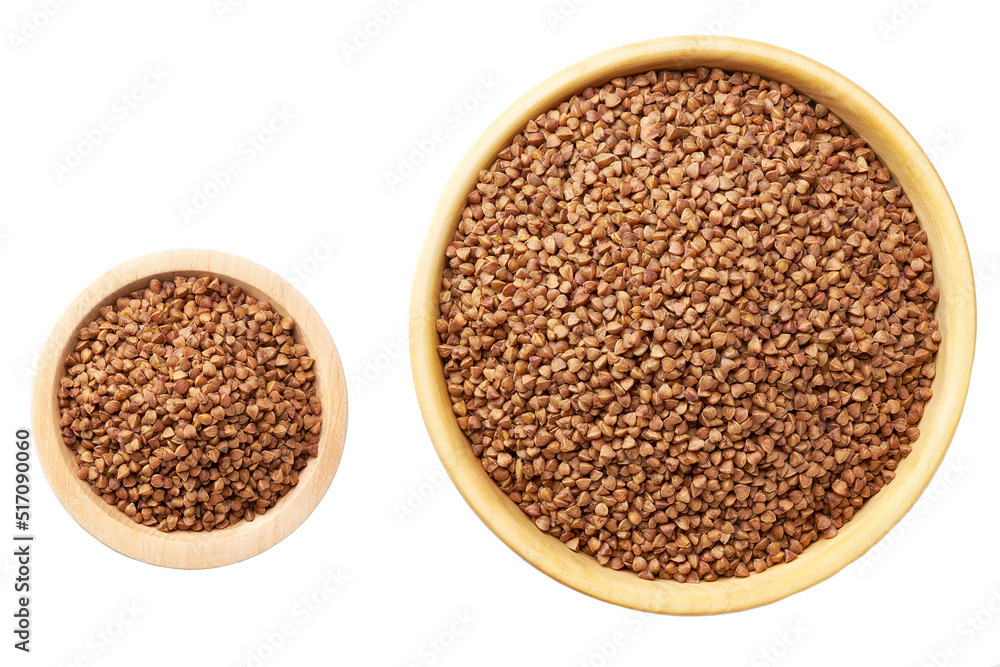 Raw buckwheat in a wooden bowl isolated on white background top view. Raw buckwheat in a wooden bowl isolated on white background top view.