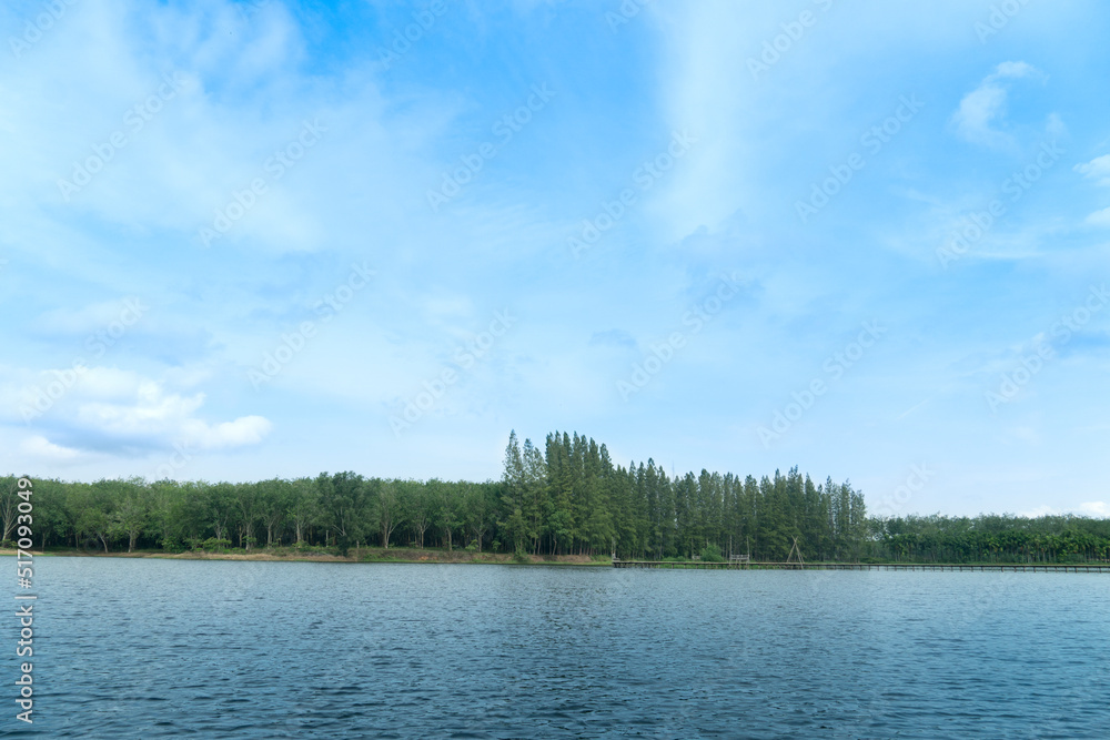 Landscape view of nature Reservoir with light waves. Along the wooden bridge is far away in the tourist attraction. with green trees for backgound under blue sky. Landscape view of nature Reservoir with light waves. Along the wooden bridge is far away in the tourist attraction. with green trees for backgound under blue sky.