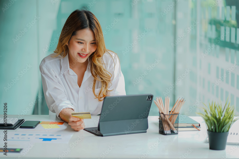 young businesswoman holding credit card online shopping with tablet attractive woman holding credit card and doing online financial transactions with digital tablet online shopping young businesswoman holding credit card online shopping with tablet attractive woman holding credit card and doing online financial transactions with digital tablet online shopping