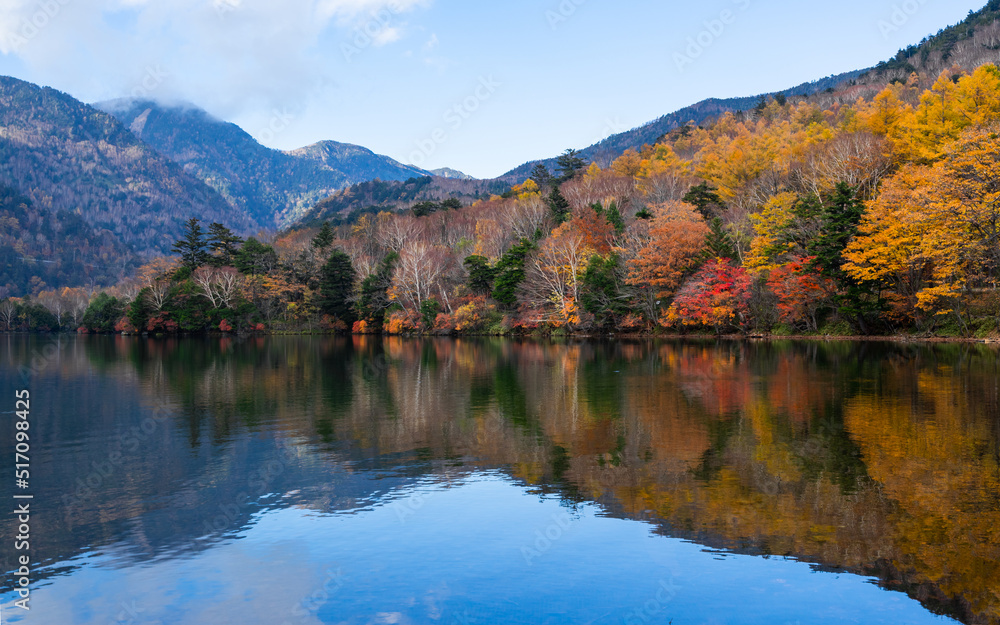 Beautiful autumn landscape with reflection against blue sky. Colorful mountain at Nikko, Japan.