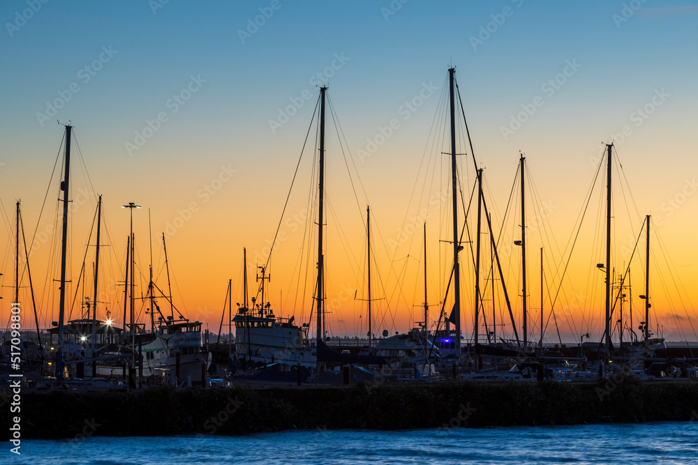 Sailboats in the harbor during a sunset