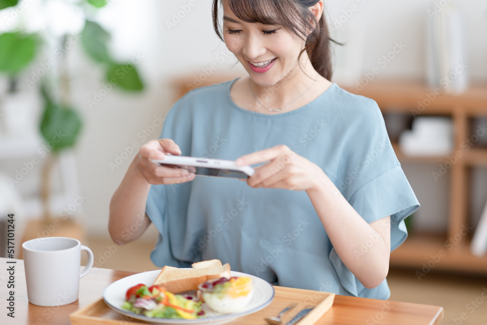 朝食の写真を撮る女性