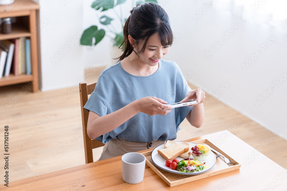 朝食の写真を撮る女性