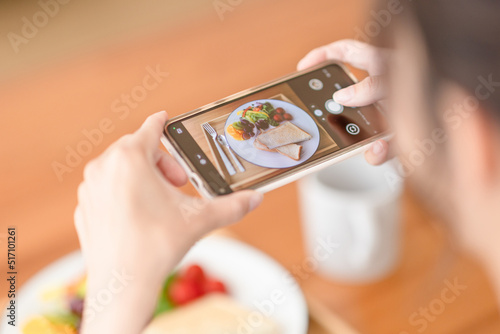 朝食の写真を撮る女性