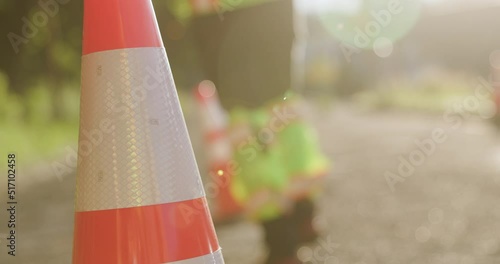 Road Construction Flagger Placing Traffic Cones Along Road