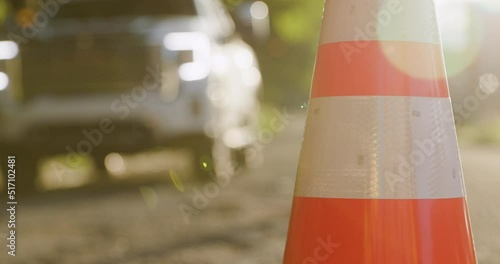Car Slowly Driving Along Road with Construction Traffic Cone