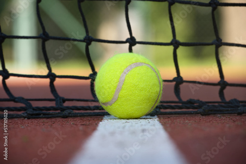 Tennis scene with black net, ball on white line photo