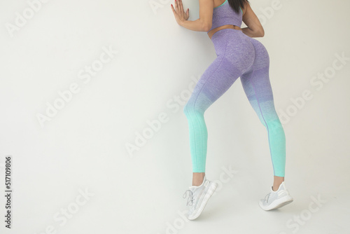 Canvas Print A big woman booty in leggings on grey background.