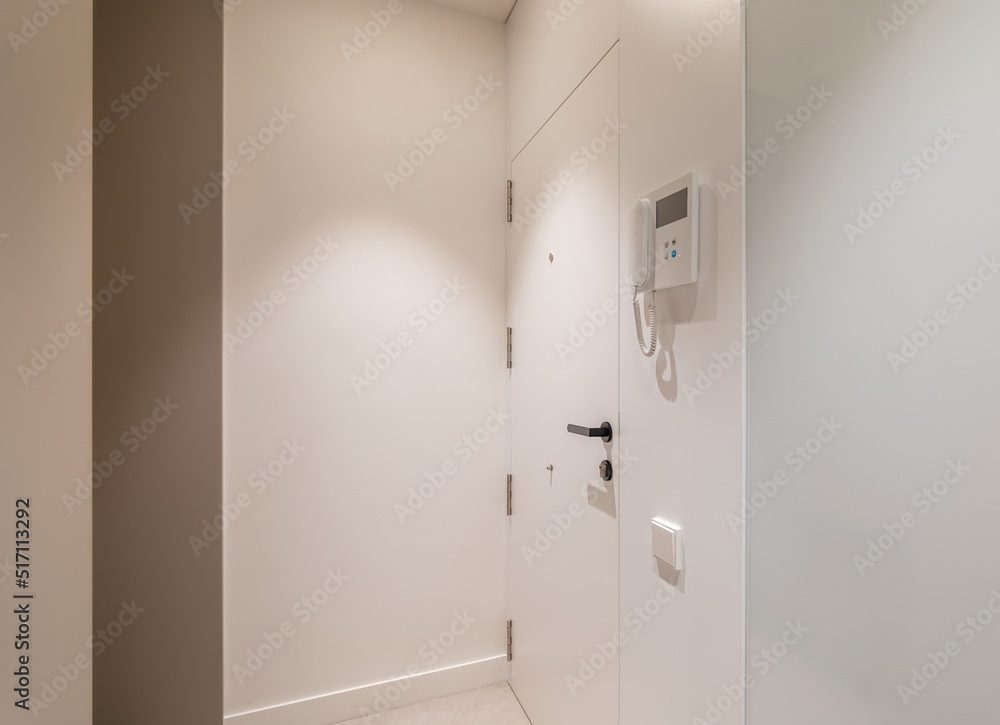 Entrance hall area in modern refurbished apartment. White walls and door with intercom system. Entrance hall area in modern refurbished apartment. White walls and door with intercom system.