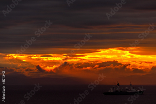 Bright dawn in the sea. Beautiful scarlet and red clouds during a colorful sunrise in Vladivostok.