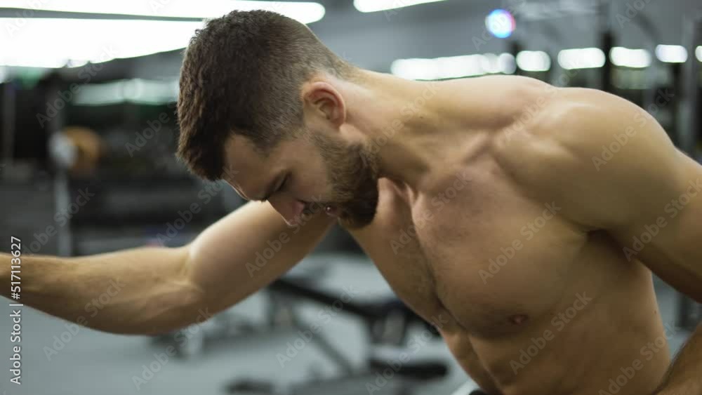 Fitness man athlete training hand muscles, enjoying difficult endurance practice in gym Fitness man athlete training hand muscles, enjoying difficult endurance practice in gym