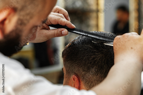 Male client getting haircut by hairdresser in barbershop © fotofabrika