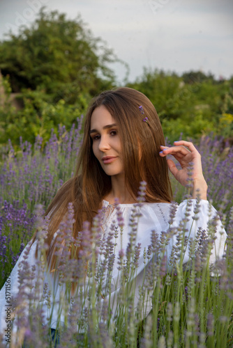relaxing brunette beautiful girl in lavender field in white dress