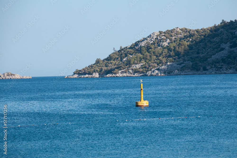 Fototapeta premium Yellow Sea Buoy in turquoise water of Mediterranean Sea. Marine Navigation Buoy. Safe water mark