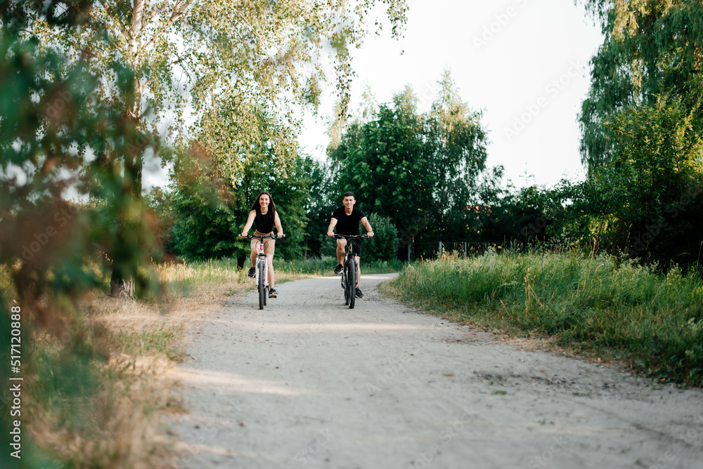 Boy and girl walking on bikes in the park Boy and girl walking on bikes in the park