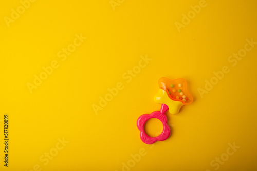 Baby rattle on yellow background
